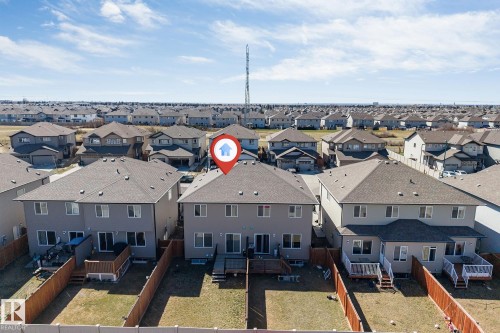 Rear exterior featuring a spacious wooden deck with railings, an additional ground-level patio, and a partially fenced backyard - 1715 27 Street, Edmonton, AB - Outdoor