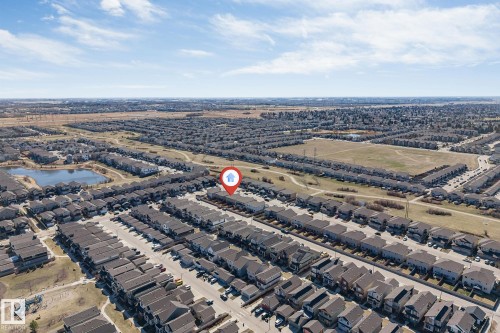 Aerial view of a residential community featuring a prominent pond, a large open green space, and extensive housing developments - 1715 27 Street, Edmonton, AB - Outdoor With View