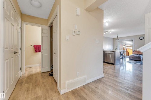 Wood-finish flooring extending from the hallway into the kitchen and living areas - 1715 27 Street, Edmonton, AB - Indoor Photo Showing Other Room