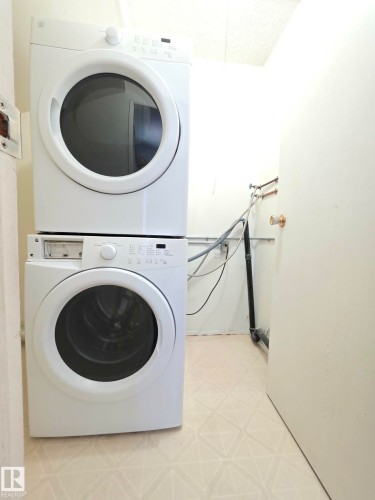 Dedicated laundry area featuring a stacked white washer and dryer unit - 304 34 Alpine Place, St. Albert, AB - Indoor Photo Showing Laundry Room