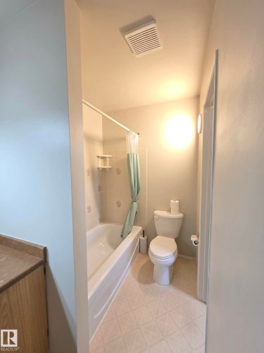 Full bathroom featuring a white bathtub, white toilet, patterned floor tiles, and a built-in ventilation system - 304 34 Alpine Place, St. Albert, AB - Indoor Photo Showing Bathroom