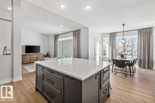 Kitchen island featuring a light-toned countertop and built-in microwave - 7719 166 Avenue, Edmonton, AB - Indoor