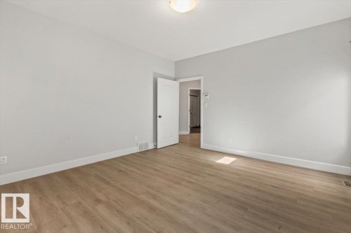 Spacious room with light wood-finish flooring and neutral gray walls - 7719 166 Avenue, Edmonton, AB - Indoor Photo Showing Other Room
