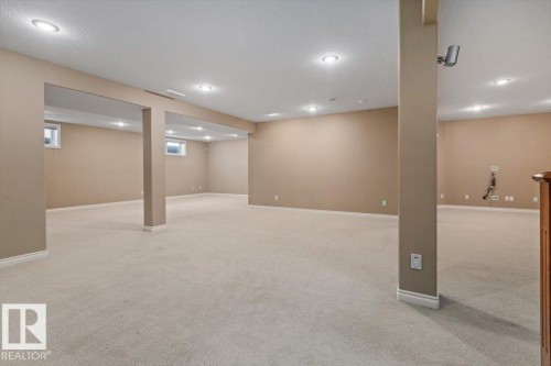 Spacious lower level featuring plush carpeting, recessed lighting, neutral wall tones, and multiple egress windows - 7719 166 Avenue, Edmonton, AB - Indoor Photo Showing Basement