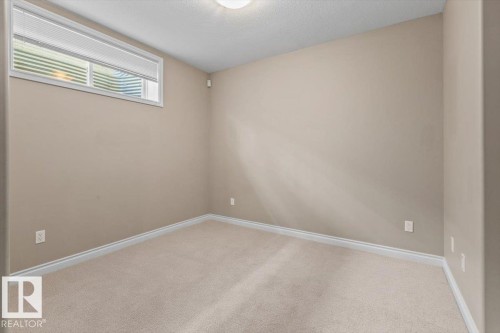 Neutral tone walls, ceiling-mounted light fixture, white window blinds, white trim, and beige carpeting - 7719 166 Avenue, Edmonton, AB - Indoor Photo Showing Other Room