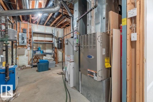 Utility area featuring exposed ceiling joists, galvanized steel ductwork, concrete flooring, and a Carrier HVAC unit - 7719 166 Avenue, Edmonton, AB - Indoor Photo Showing Basement