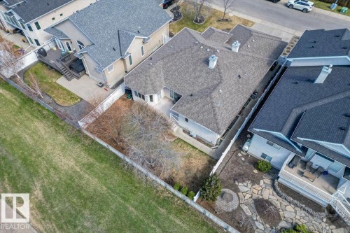Residential property featuring a grey shingle roof, multiple chimneys, and a fenced backyard - 7719 166 Avenue, Edmonton, AB - Outdoor