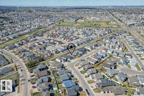 Aerial view of a residential neighborhood with numerous detached homes, street infrastructure, and multiple green spaces - 7719 166 Avenue, Edmonton, AB - 