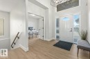 Foyer featuring wood-finish flooring, a white paneled entry door with an arched window, and sidelight windows - 7719 166 Avenue, Edmonton, AB  - Indoor Photo Showing Other Room 