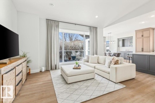 Open-concept living space featuring wood-finish flooring, recessed lighting, and a large bay window - 7719 166 Avenue, Edmonton, AB - Indoor Photo Showing Living Room