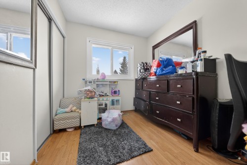 Interior space featuring wood-finish flooring, light-toned walls, and a window providing natural illumination - 8312 29 Ave Nw, Edmonton, AB - Indoor
