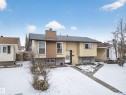 Split-level home featuring light-colored siding, a dark shingle roof, and a prominent chimney - 8312 29 Ave Nw, Edmonton, AB  - Outdoor 