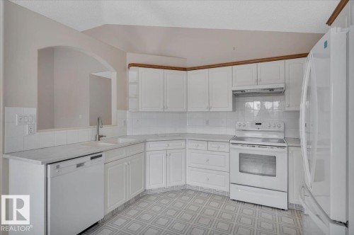 The kitchen features white cabinetry, white appliances, and a tiled backsplash - 19 1203 Carter Crest Road, Edmonton, AB - Indoor Photo Showing Kitchen
