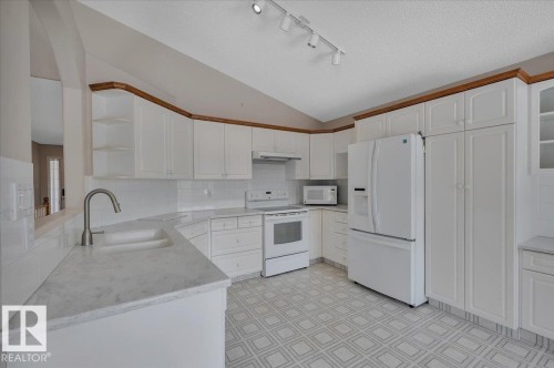 Kitchen featuring white cabinetry, a built-in sink, and white appliances including a refrigerator, stove, and microwave - 19 1203 Carter Crest Road, Edmonton, AB - Indoor Photo Showing Kitchen