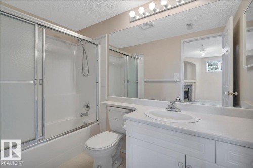 Bathroom featuring a tub and shower combination with sliding glass doors in the basement - 19 1203 Carter Crest Road, Edmonton, AB - Indoor Photo Showing Bathroom