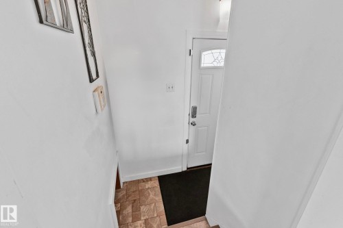 White entry door with decorative glass insert and keypad lock - 13516 104A Street, Edmonton, AB - Indoor Photo Showing Other Room