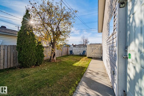 Private fenced yard with mature trees and a concrete pathway - 13516 104A Street, Edmonton, AB - Outdoor