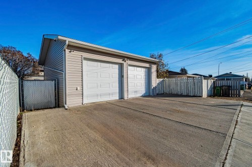 Detached two-car garage with light-colored siding and two white garage doors - 13516 104A Street, Edmonton, AB - Outdoor With Exterior
