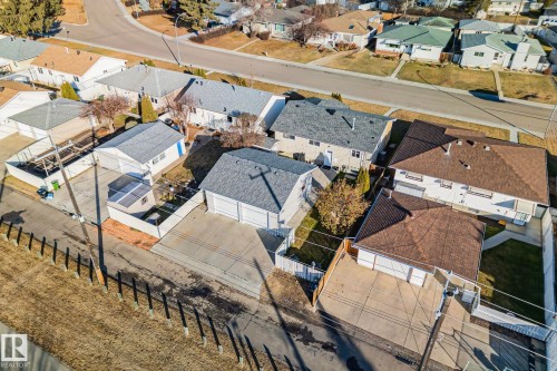 Aerial perspective showcasing multiple properties with paved driveways and fenced yards - 13516 104A Street, Edmonton, AB - Outdoor