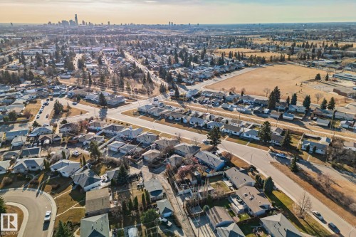 Expansive neighborhood featuring residential homes, mature trees, open fields, and distant city skyline - 13516 104A Street, Edmonton, AB - Outdoor With View