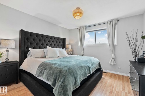 Bedroom featuring light wood-finish flooring, light gray wall paint, and a window with white trim - 13516 104A Street, Edmonton, AB - Indoor Photo Showing Bedroom