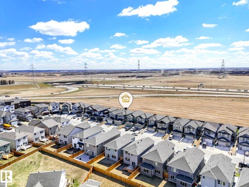 Residential development featuring multiple two-story homes with attached garages, individual fenced yards, and direct road access - 2435 12 Avenue, Edmonton, AB - Outdoor With View