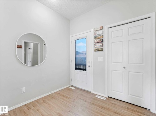 Entryway featuring a light wood-finish floor, white walls, and a white front door with an integrated window - 2435 12 Avenue, Edmonton, AB - Indoor Photo Showing Other Room