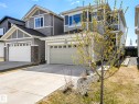 Contemporary gray siding exterior with white trim accents and a prominent two-car garage - 2435 12 Avenue, Edmonton, AB  - Outdoor With Facade 