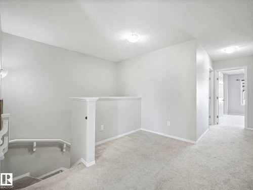 Upper-level hallway featuring light gray walls, white trim, and soft gray carpeting - 2435 12 Avenue, Edmonton, AB - Indoor Photo Showing Other Room