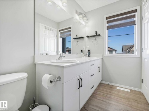 Bathroom featuring a double vanity with white cabinetry and integrated sinks - 2435 12 Avenue, Edmonton, AB - Indoor Photo Showing Bathroom