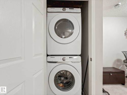 Stackable washer and dryer unit in a dedicated alcove - 2435 12 Avenue, Edmonton, AB - Indoor Photo Showing Laundry Room