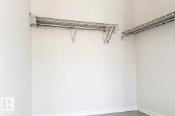 Closet featuring white-painted walls, wire shelving, and hanging rods - 