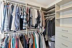 Custom built-in closet system featuring multiple hanging rods, integrated shelving, and dedicated drawer storage with brushed nickel hardware - 