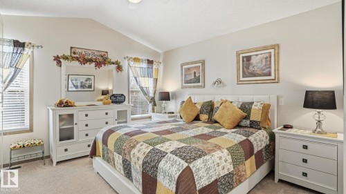 Carpeted sleeping area featuring a vaulted ceiling, white walls, and twin windows with blinds - 5 Richelieu Place, Beaumont, AB - Indoor Photo Showing Bedroom