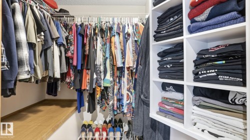 Custom closet system featuring white wire shelving, built-in cubbies, and a wood-finish bench - 5 Richelieu Place, Beaumont, AB - Indoor With Storage