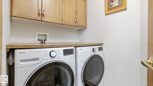 Functional laundry area featuring upper cabinetry, a solid surface countertop, and dedicated appliance space - 5 Richelieu Place, Beaumont, AB - Indoor Photo Showing Laundry Room