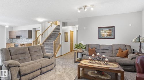 Open-concept living space featuring light gray walls and textured carpeting - 5 Richelieu Place, Beaumont, AB - Indoor Photo Showing Living Room