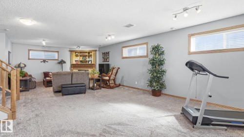 Spacious lower level featuring plush carpeting, light gray walls, and multiple egress windows with wood trim - 5 Richelieu Place, Beaumont, AB - Indoor