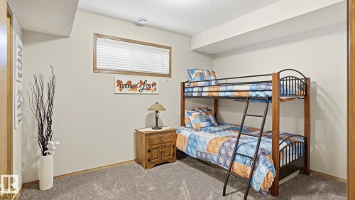 Carpeted room featuring a window with horizontal blinds and a wood-framed trim - 5 Richelieu Place, Beaumont, AB - Indoor Photo Showing Bedroom