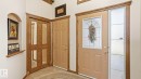 Entryway featuring a decorative front door with leaded glass, an adjacent sidelight with textured glass, and a paneled interior door - 5 Richelieu Place, Beaumont, AB  - Indoor Photo Showing Other Room 