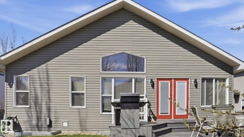 Rear exterior featuring gray horizontal siding, a gabled roofline with white trim, and a multi-level deck - 5 Richelieu Place, Beaumont, AB - Outdoor With Exterior