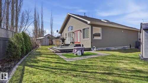 Expansive backyard featuring a manicured lawn and mature trees - 5 Richelieu Place, Beaumont, AB - Outdoor