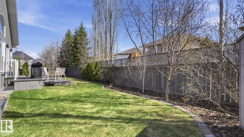 Expansive backyard featuring a manicured lawn, a raised composite deck, and established perimeter landscaping - 5 Richelieu Place, Beaumont, AB - Outdoor