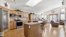 Open-concept living area featuring a kitchen with light wood cabinetry, stainless steel appliances, and a central island with a sink - 5 Richelieu Place, Beaumont, AB  - Indoor Photo Showing Kitchen 