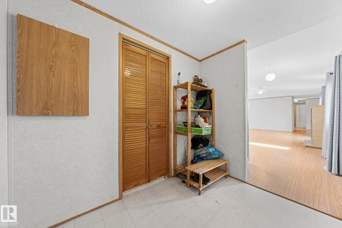 Entryway featuring a wood-finish bi-fold louvered door, neutral wall paneling, and a tiled floor - 623 Evergreen Park, Edmonton, AB - Indoor Photo Showing Other Room