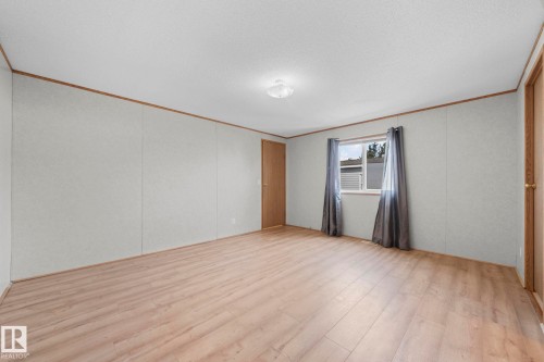 Spacious room with wood-finish flooring, white panel walls, and wood trim accents - 623 Evergreen Park, Edmonton, AB - Indoor Photo Showing Other Room