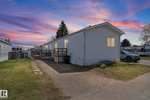 White siding exterior featuring a pitched roof, front porch with wooden railing, and a paved driveway - 623 Evergreen Park, Edmonton, AB - Outdoor