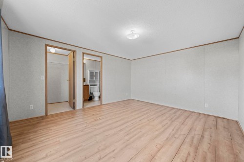 Spacious room featuring wood-finish flooring, white panel walls, and a ceiling-mounted light fixture - 623 Evergreen Park, Edmonton, AB - Indoor Photo Showing Other Room