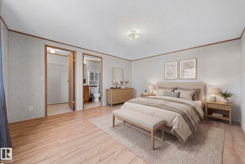 Spacious room featuring wood-finish flooring, two doorways, and a flush-mount ceiling light fixture - 623 Evergreen Park, Edmonton, AB - Indoor Photo Showing Bedroom