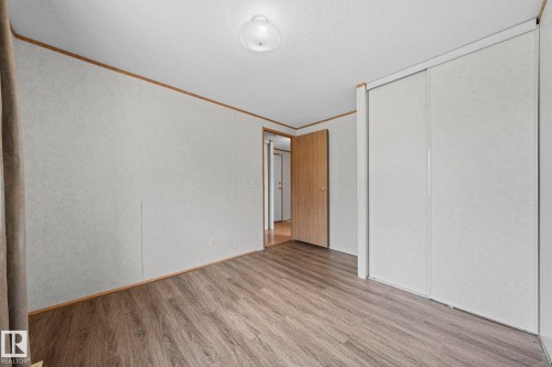 Spacious room featuring wood-finish flooring, light-toned walls, and a ceiling-mounted light fixture - 623 Evergreen Park, Edmonton, AB - Indoor Photo Showing Other Room